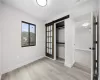 Unfurnished bedroom featuring light hardwood / wood-style floors, a closet, and a barn door