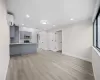 Kitchen with a wall mounted AC, light hardwood / wood-style floors, kitchen peninsula, gray cabinets, and appliances with stainless steel finishes