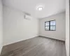 Unfurnished room with a wall mounted AC and light hardwood / wood-style floors