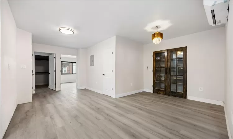 Unfurnished room featuring light wood-type flooring and an inviting chandelier