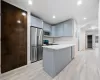 Kitchen with stainless steel appliances, light hardwood / wood-style floors, and light stone counters