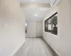 Hallway with light hardwood / wood-style flooring, lofted ceiling, and a wall mounted air conditioner