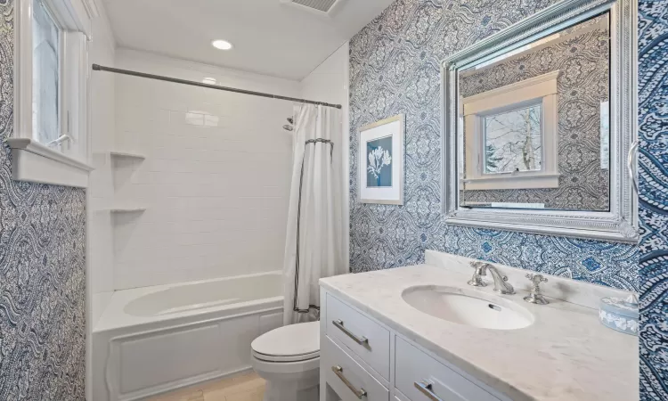 Full bathroom featuring toilet, vanity, and shower / bath combo with shower curtain