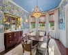 Dining room featuring an inviting chandelier, dark hardwood / wood-style flooring, and crown molding