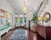 Living area featuring an inviting chandelier, dark hardwood / wood-style flooring, crown molding, and built in features