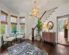 Sitting room featuring a wealth of natural light, crown molding, wood-type flooring, and a notable chandelier