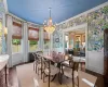 Dining area featuring an AC wall unit, radiator heating unit, dark wood-type flooring, a notable chandelier, and crown molding