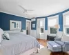 Bedroom featuring hardwood / wood-style floors, ceiling fan, ornamental molding, an AC wall unit, and radiator heating unit