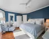 Bedroom with ceiling fan, hardwood / wood-style flooring, and crown molding