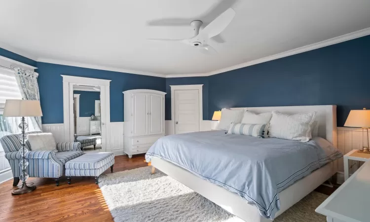 Bedroom with ceiling fan, hardwood / wood-style flooring, and crown molding