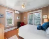 Bedroom with hardwood / wood-style floors, ceiling fan, a wall mounted air conditioner, radiator, and ornamental molding