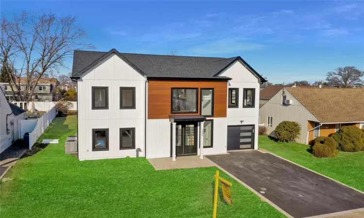 Modern farmhouse with a front lawn and a garage