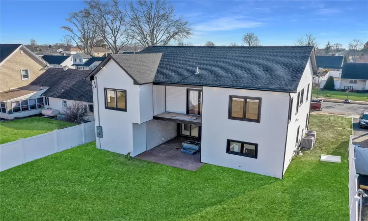 Rear view of property featuring a patio area and a lawn