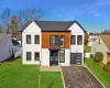 View of front facade featuring a garage, a front lawn, and french doors