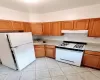 Kitchen with sink, white appliances, and light tile patterned floors