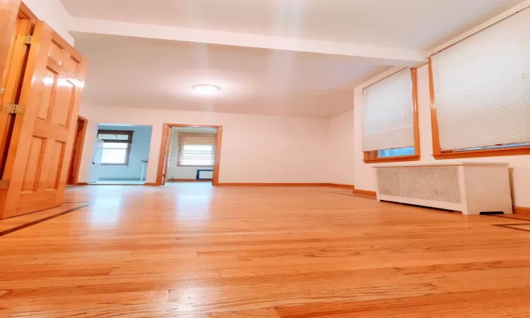 Unfurnished living room featuring light hardwood / wood-style floors and radiator