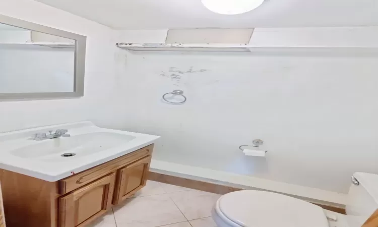 Bathroom featuring toilet, vanity, and tile patterned floors