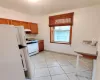 Kitchen featuring light tile patterned floors and white appliances