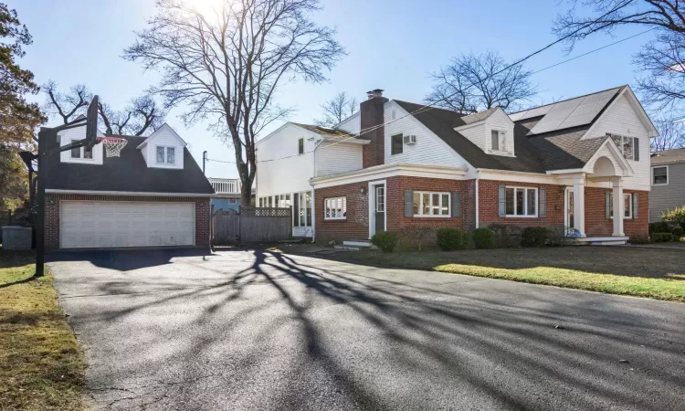 View of home's exterior with solar panels and a garage