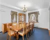 Carpeted dining area featuring a notable chandelier, a wall unit AC, and a baseboard heating unit