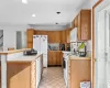 Kitchen featuring white appliances, a kitchen bar, light tile patterned floors, and a center island