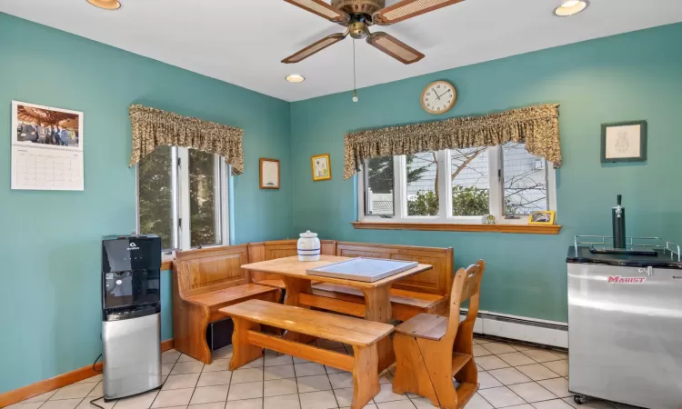 Tiled dining room featuring ceiling fan and a baseboard radiator