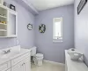 Bathroom with toilet, tile patterned flooring, and vanity