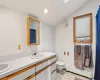 Bathroom with tile patterned flooring, vaulted ceiling, toilet, vanity, and a baseboard radiator