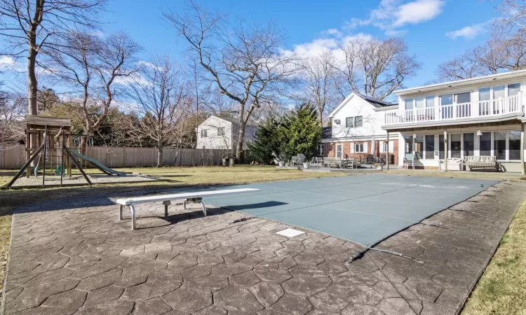 View of pool featuring a diving board, a yard, a playground, and a patio