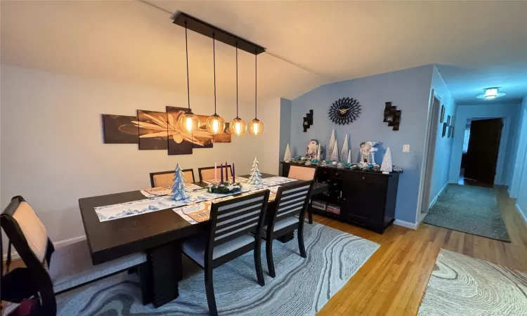 Dining space featuring vaulted ceiling and light hardwood / wood-style floors