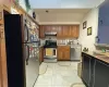 Kitchen with light tile patterned floors, appliances with stainless steel finishes, and tasteful backsplash