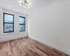 Empty room with an inviting chandelier and light hardwood / wood-style flooring