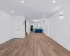 Unfurnished living room featuring light wood-type flooring and an AC wall unit