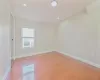 Unfurnished room with light hardwood / wood-style floors and lofted ceiling