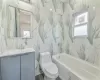 Full bathroom with toilet, a wealth of natural light, tile walls, and vanity