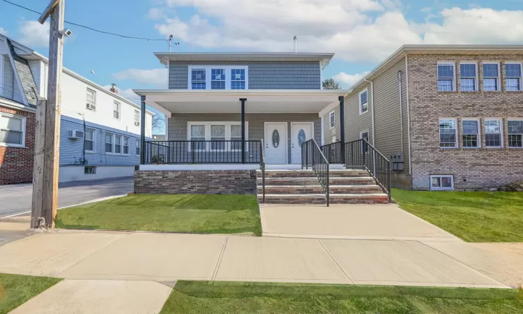 View of front facade featuring a porch and a front yard