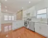 Kitchen with appliances with stainless steel finishes, white cabinetry, sink, backsplash, and kitchen peninsula