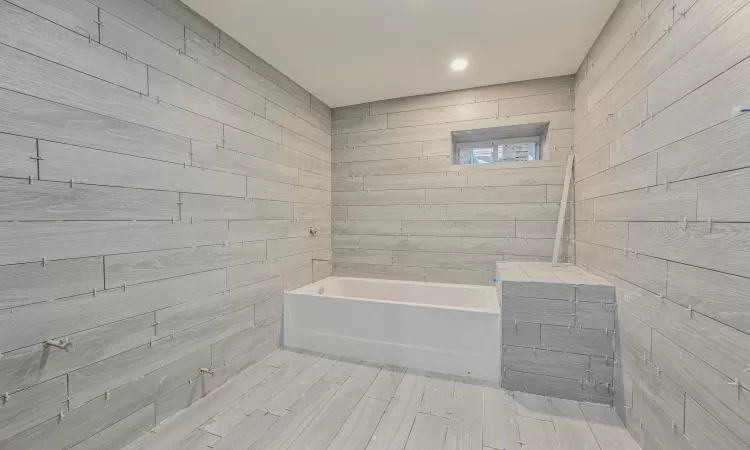 Bathroom with tile walls and a tub