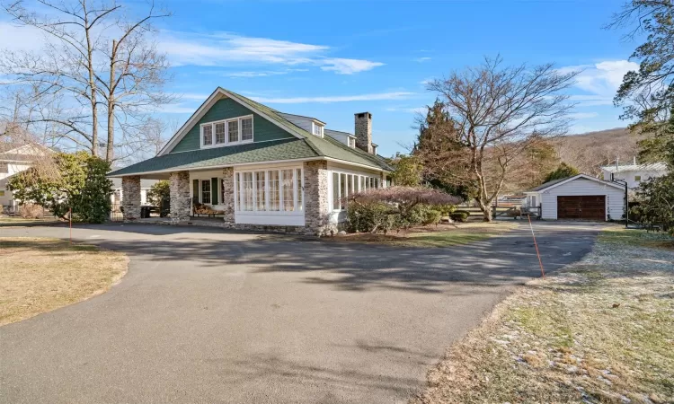 View of front of house featuring a porch, an outdoor structure, and a garage