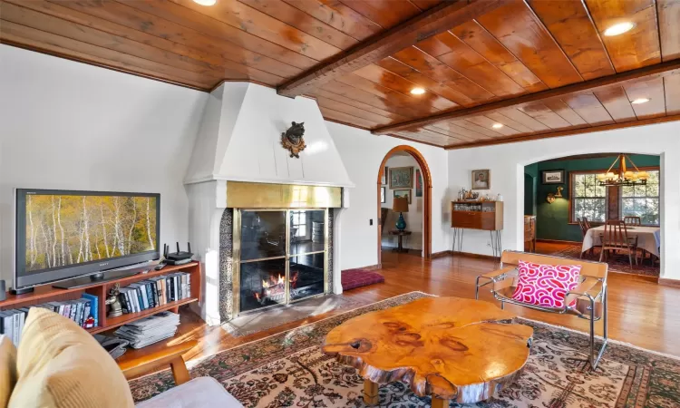 Living room featuring beam ceiling, wood-type flooring, wood ceiling, and a chandelier