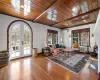 Living room featuring wooden ceiling, a wall mounted AC, beam ceiling, and radiator heating unit