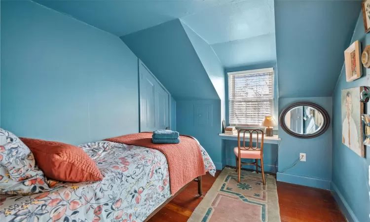 Bedroom featuring dark hardwood / wood-style flooring and vaulted ceiling