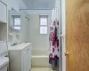 Full bathroom featuring toilet, shower / bath combo with shower curtain, tile patterned flooring, tile walls, and vanity