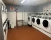 Washroom featuring stacked washer / dryer, dark tile patterned flooring, and separate washer and dryer