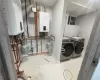 Utility room with tankless water heater and washer and clothes dryer