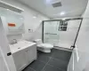 Bathroom featuring an enclosed shower, tile patterned floors, vanity, tile walls, and toilet