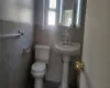 Bathroom featuring toilet and tile walls