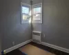 Empty room with radiator and dark wood-type flooring