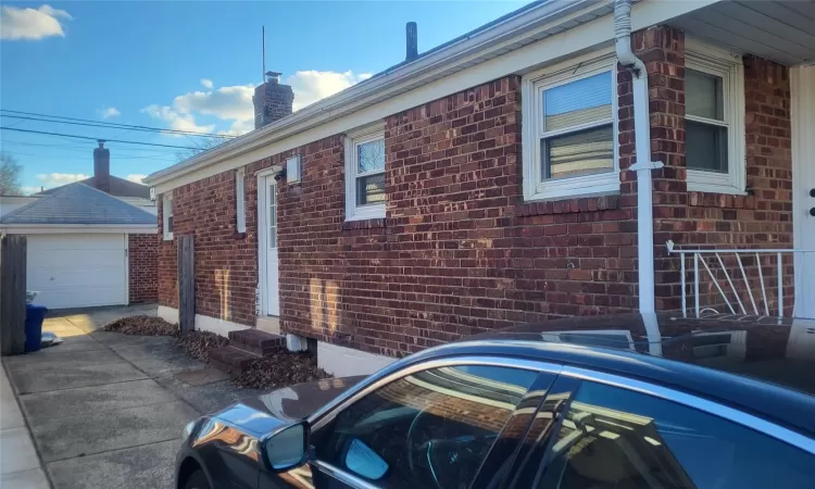 View of home's exterior with a garage and an outbuilding