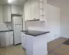 Kitchen with backsplash, white cabinets, ornamental molding, and white fridge